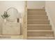 View of a staircase with tan carpeting complemented by a modern table and mirror at 1816 Otter Perch Ln, Fort Mill, SC 29715