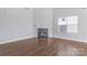 Bright living room featuring hardwood floors, a fireplace, and a large window at 1911 Kingstree Dr, Monroe, NC 28112