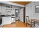 Bright kitchen featuring white cabinets, shelving, and view to exterior door at 201 Hoskins S Rd # 124, Charlotte, NC 28208