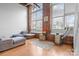 Living room with large windows, exposed brick, hardwood floors, and comfortable seating at 201 Hoskins S Rd # 124, Charlotte, NC 28208