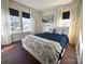 Bright bedroom featuring three sunny windows, white curtains, and navy duvet with floral throw at 269 Loch Stone St, Fort Mill, SC 29715