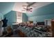 Bright blue bedroom featuring a ceiling fan, window, and various items on and around the bed at 3230 Creek Bend Ct, Sherrills Ford, NC 28673