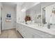 Bright bathroom with a double sink vanity, large mirror, and wood-look tile flooring at 324 Basil Dr, Indian Trail, NC 28079