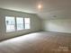 Spacious bedroom featuring multiple windows, neutral carpeting and a large open layout at 324 Basil Dr, Indian Trail, NC 28079