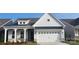 Charming home with a two-car garage, craftsman style porch, stone accents, and vertical siding detail at 324 Basil Dr, Indian Trail, NC 28079