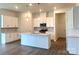 Bright kitchen with white cabinets, stainless steel appliances, and a spacious island with a sink at 324 Basil Dr, Indian Trail, NC 28079
