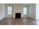 Cozy living room with a fireplace, large windows for natural light, and hardwood flooring at 324 Basil Dr, Indian Trail, NC 28079