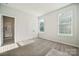 Comfortable bedroom with plush carpeting, two large windows, and a door leading to an ensuite bathroom at 4011 Vista Pine Dr, Charlotte, NC 28215