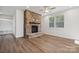 Charming living room with a stone fireplace, built in shelving, and hardwood floors at 4011 Vista Pine Dr, Charlotte, NC 28215