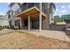 Backyard patio beneath a balcony; brick home with stone retaining wall, landscaping, and sliding glass doors at 4069 Rivendell Rd # 5, Denver, NC 28037