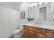 Bathroom featuring wood vanity, mirror, sconces, with a white shower curtain and toilet at 4069 Rivendell Rd # 5, Denver, NC 28037