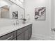 Bathroom featuring dark vanity, mirror, sconces, and artwork on the wall at 4069 Rivendell Rd # 5, Denver, NC 28037