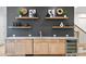 Elegant wet bar featuring natural wood cabinetry, light countertop, floating shelves, decor, and a wine cooler at 4069 Rivendell Rd # 5, Denver, NC 28037