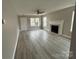 Bright living room with a fireplace, ceiling fan, and wood-look floors at 4904 Cornelia Dr, Charlotte, NC 28269