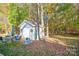 Backyard with a storage shed, green grass, and colorful trees at 541 Settlers Grove Ln # 49, Salisbury, NC 28146