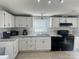 Well-lit kitchen with white cabinets, dark appliances, and ample counter space at 6106 Ashley Dr, Concord, NC 28025