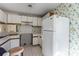 Cozy kitchen featuring white cabinets, floral wallpaper, and vintage-style flooring at 657 Heathridge Rd, Rock Hill, SC 29732