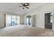 Bright living room with large windows, neutral carpet, ceiling fan, and open doorway to adjacent rooms at 657 Heathridge Rd, Rock Hill, SC 29732