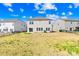 Backyard view of a newly constructed home with a grassy yard, fence, and blue skies at 7314 Rupell Dr, Charlotte, NC 28273