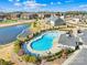 An aerial view of a community pool featuring lounge chairs and landscaped grounds beside a tranquil pond at 7314 Rupell Dr, Charlotte, NC 28273