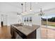 Kitchen island with stainless steel sink, granite countertops and view to backyard sliding glass doors at 7314 Rupell Dr, Charlotte, NC 28273