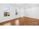 Well-lit living room with hardwood floors, two large windows, and a view to the outside at 7314 Rupell Dr, Charlotte, NC 28273