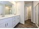 Modern bathroom showcasing double sinks, white cabinetry, and wood-look flooring at 828 Blue Canyon Dr, York, SC 29745