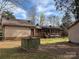 Exterior shot of home showcasing the well-maintained backyard with a stone-lined well, and outbuildings at 8609 William Wiley Dr, Charlotte, NC 28215