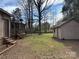 View of backyard showing home's enclosed porch, outbuildings, and lush greenery at 8609 William Wiley Dr, Charlotte, NC 28215