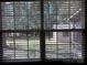 View of the backyard from the inside looking out through the shuttered window at 8609 William Wiley Dr, Charlotte, NC 28215