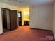 A simple bedroom featuring neutral walls, carpeted floors, and an attached bathroom at 8609 William Wiley Dr, Charlotte, NC 28215