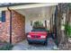 Covered carport with red brick wall and black trim, providing convenient parking at 1041 Cutler Pl, Charlotte, NC 28212