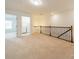 Spacious loft with railing, carpet, and lighting, leading to laundry room and a bedroom at 113 Burlingame Ct # C, Mooresville, NC 28117