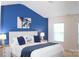 Stylish main bedroom featuring a blue accent wall, ceiling fan, and a comfy king bed at 113 Burlingame Ct # C, Mooresville, NC 28117