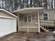 Charming home exterior with a covered porch and adjacent garage nestled among tall trees at 1138 Stateline Rd # 1, Lake Wylie, SC 29710