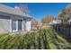 A view of a backyard with a wooden fence and grassy area next to the side of the house and a small patio at 114 Indian Paint Brush Dr, Mooresville, NC 28115