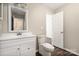 Bright bathroom features a modern white vanity, toilet, and doorway leading to additional space at 114 Indian Paint Brush Dr, Mooresville, NC 28115