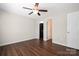 Neutral bedroom with ceiling fan, wood-look floors, and closet and bathroom entrances at 114 Indian Paint Brush Dr, Mooresville, NC 28115