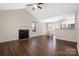 Open-concept living room with high ceilings, fireplace, and hardwood floors flowing into the dining area at 114 Indian Paint Brush Dr, Mooresville, NC 28115