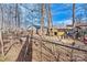 Fenced backyard featuring a chicken coop, trees, and a natural environment, ideal for raising chickens at 1140 Knollwood Dr, Claremont, NC 28610