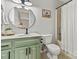 Charming bathroom with green vanity, round mirror, and shower with patterned curtain at 1140 Knollwood Dr, Claremont, NC 28610