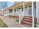 Charming home featuring a welcoming covered porch, brick-lined steps and foundation, and a 'Welcome' door decoration at 1140 Knollwood Dr, Claremont, NC 28610