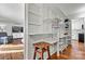 Open pantry next to the Living Room with white shelving and hardwood floors at 1140 Knollwood Dr, Claremont, NC 28610