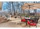 Backyard patio with red cushioned chairs, a black table, and an umbrella, creating a relaxing outdoor dining area at 1140 Knollwood Dr, Claremont, NC 28610