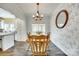 Bright dining room with modern chandelier, stylish wallpaper, and seamless flow to kitchen at 1370 Martin Rd, Hickory Grove, SC 29717