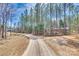 A long gravel driveway leads to this secluded property surrounded by a forest of tall, mature trees at 1370 Martin Rd, Hickory Grove, SC 29717