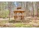 A charming wooden gazebo provides a peaceful outdoor retreat, nestled among mature trees and natural surroundings at 1370 Martin Rd, Hickory Grove, SC 29717