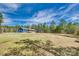 A well-manicured lawn surrounds a charming blue home, set against a backdrop of lush, mature trees at 1370 Martin Rd, Hickory Grove, SC 29717