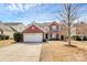 Charming two-story home with brick accents, white garage door, and a well-manicured front yard at 147 Amber Woods Dr, Tega Cay, SC 29708