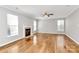 Bright living room with fireplace, hardwood floors, ceiling fan, and large windows at 147 Amber Woods Dr, Tega Cay, SC 29708